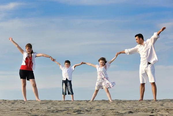 Famiglia sulla spiaggia che mostra il segno di casa — Foto Stock