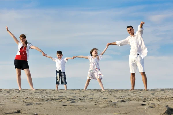 Family on beach showing home sign — Stock Photo, Image