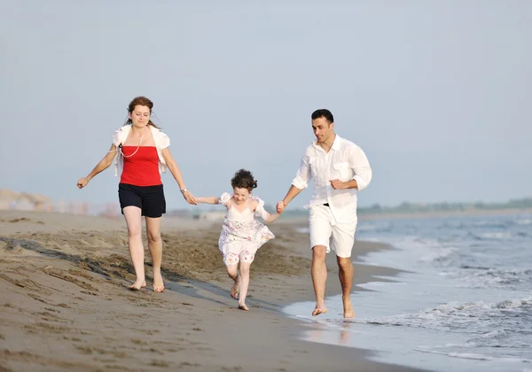Onnellinen nuori perhe pitää hauskaa rannalla — kuvapankkivalokuva
