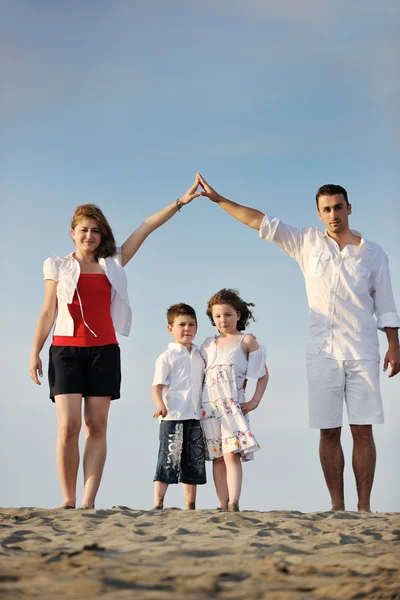 Família na praia mostrando sinal de casa — Fotografia de Stock
