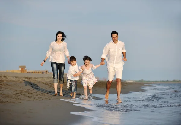 Šťastná mladá rodina bavte se na pláži — Stock fotografie