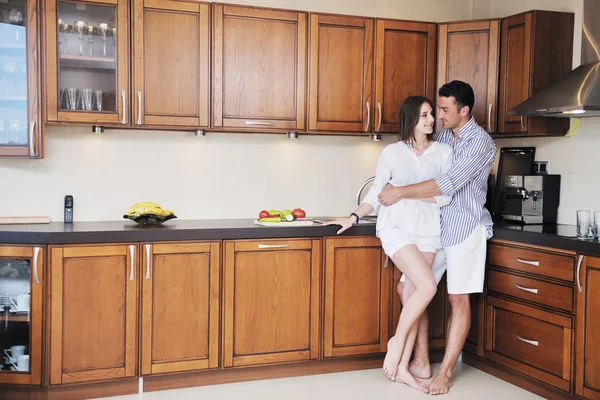 Feliz pareja joven se divierten en la cocina moderna — Foto de Stock