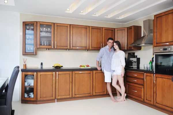 Feliz jovem casal se divertir na cozinha moderna — Fotografia de Stock