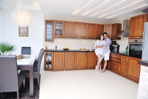Feliz jovem casal se divertir na cozinha moderna — Fotografia de Stock