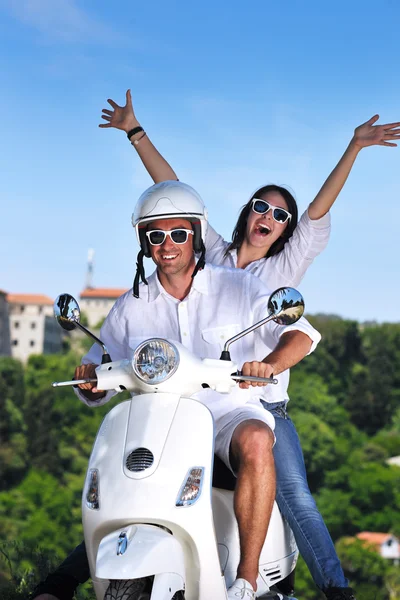 Retrato de feliz pareja de amor joven en scooter disfrutando de verano t Imagen de archivo