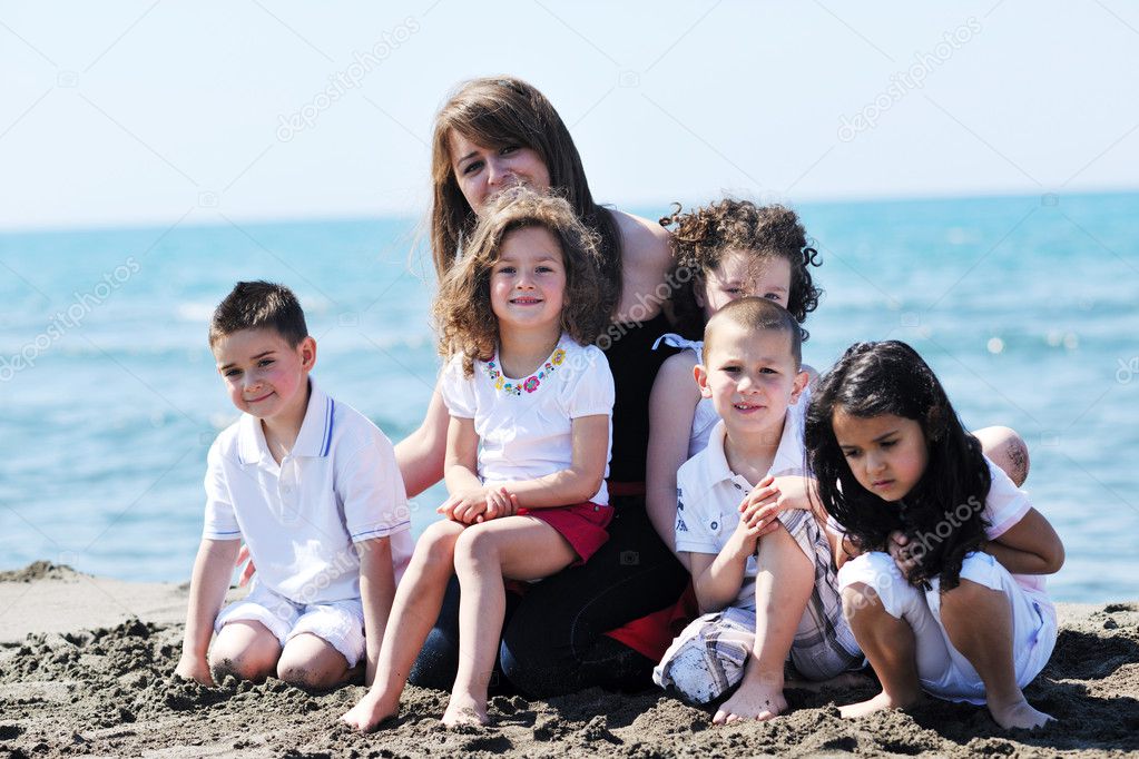 Group portrait of childrens with teacher on beach