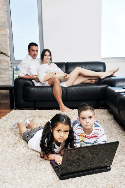 Mutlu genç aile eğlenceli ve dizüstü evde çalışma — Stok fotoğraf