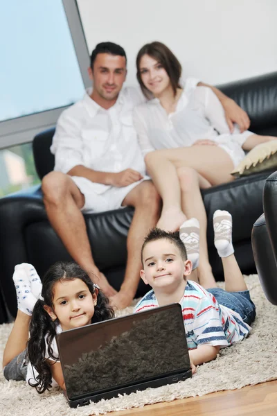 幸せな楽しいを持っている若い家族と自宅のラップトップに取り組んで — ストック写真