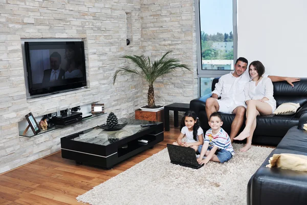 Feliz familia joven divertirse y trabajar en el ordenador portátil en casa — Foto de Stock