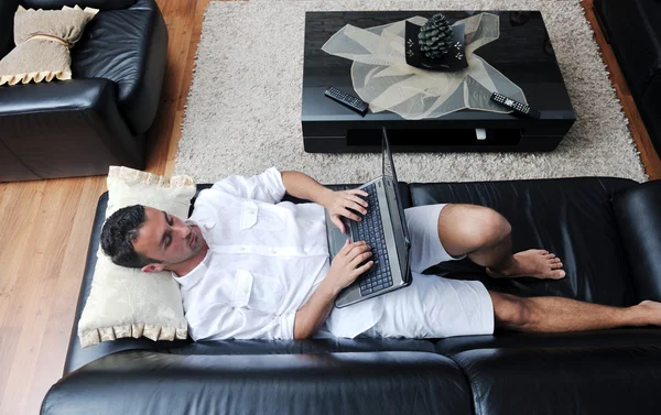 Ritratto di un giovane ragazzo rilassato che usa il portatile a casa — Foto Stock