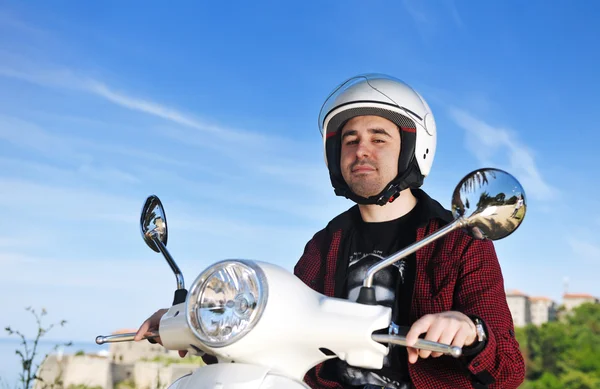 Молодой человек катается на ретро-скутере — стоковое фото