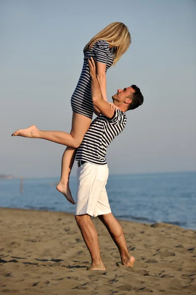 Glada unga par ha kul på stranden — Stockfoto