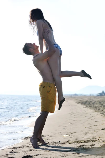 Glada unga par ha kul på stranden — Stockfoto