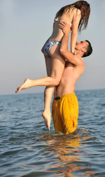Szczęśliwa młoda para baw się na plaży — Zdjęcie stockowe