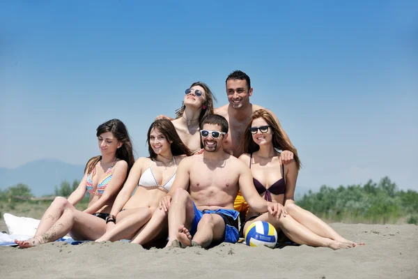 Счастливая молодая группа веселится на пляже — стоковое фото