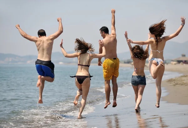 Fröhliche junge Gruppe hat Spaß am Strand — Stockfoto