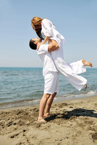 Glückliches junges Paar hat Spaß am Strand — Stockfoto