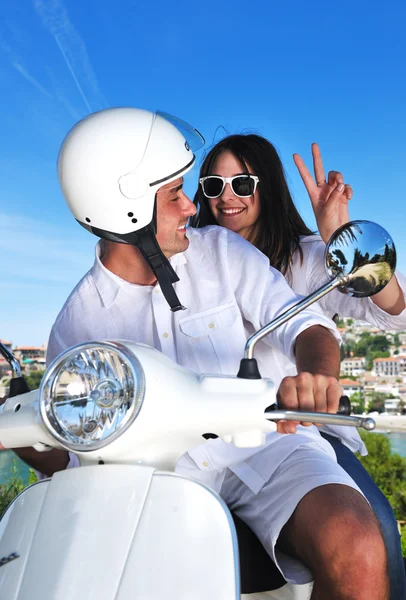 Retrato de feliz pareja de amor joven en scooter disfrutando de verano t Imágenes de stock libres de derechos