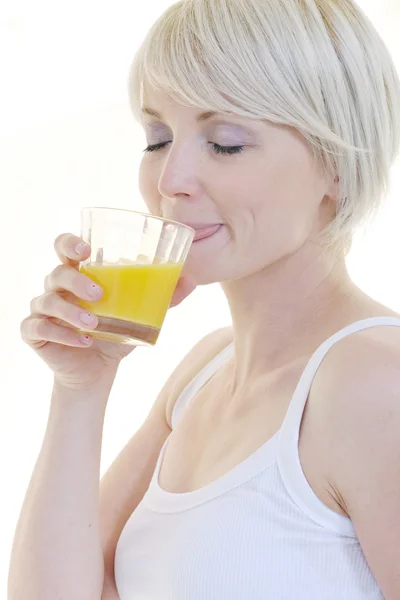 Jovem mulher espremer suco de laranja — Fotografia de Stock