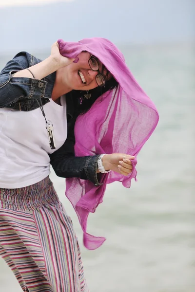 Mooie jonge vrouw op het strand met sjaal — Stockfoto