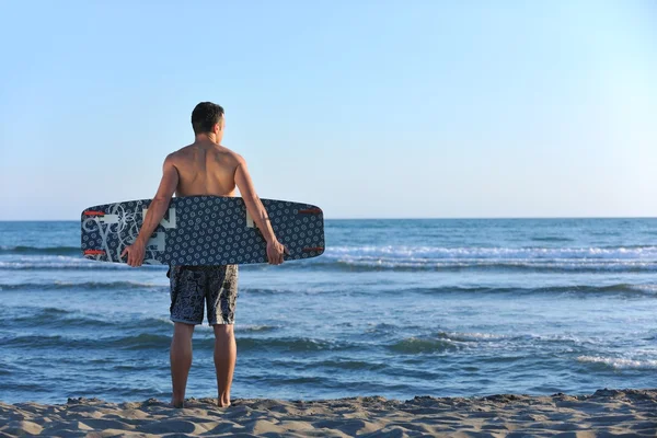 Porträtt av en ung kitsurf man på stranden vid solnedgången — Stockfoto