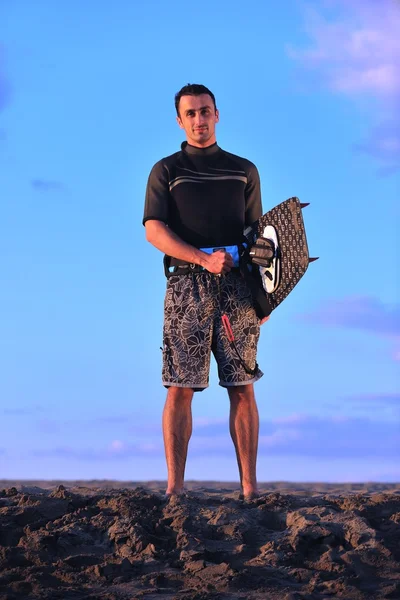 Portræt af en ung kitsurf mand ved stranden ved solnedgang - Stock-foto