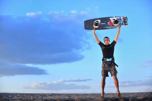 Portret van een jonge kitsurf man op strand op zonsondergang — Stockfoto