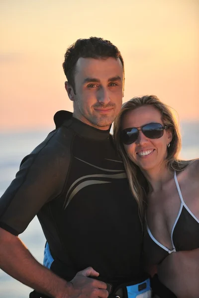 Surf par poserar på stranden på sunset — Stockfoto