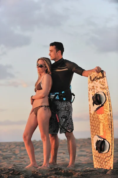 Pareja de surf posando en la playa al atardecer — Foto de Stock