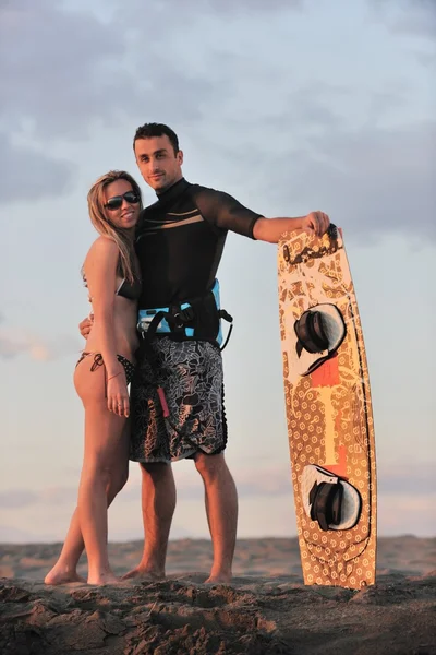 Surf pari poseeraa rannalla auringonlaskun — kuvapankkivalokuva