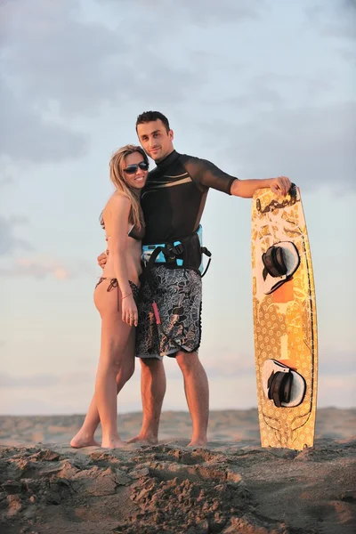 Surf coppia posa in spiaggia al tramonto — Foto Stock