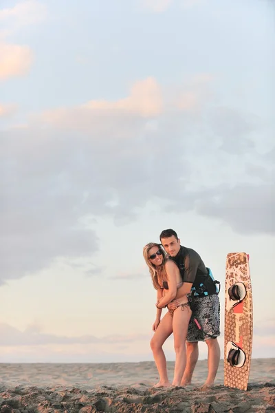 Surf par poserar på stranden på sunset — Stockfoto