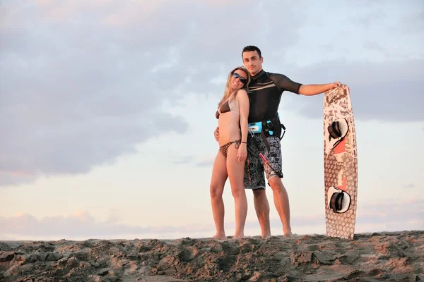 Pareja de surf posando en la playa al atardecer —  Fotos de Stock