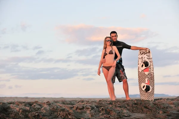 Пара серфингистов позирует на пляже на закате — стоковое фото