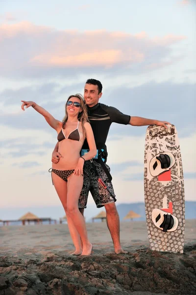 Surf paar poseren op strand op zonsondergang — Stockfoto