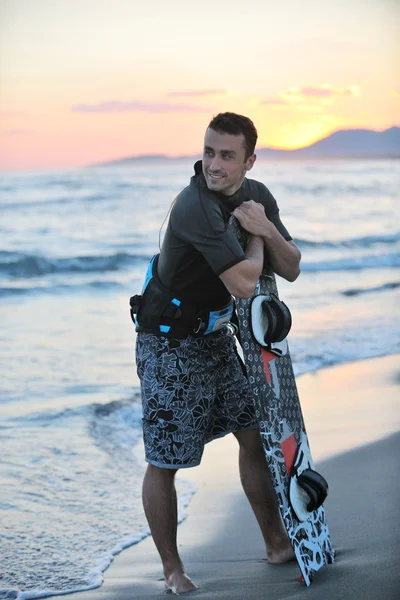 Porträtt av en ung kitsurf man på stranden vid solnedgången — Stockfoto
