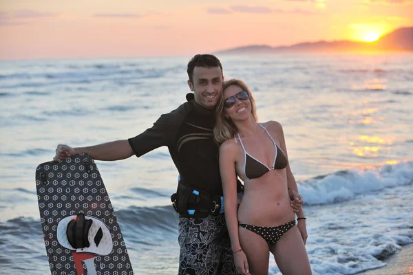 Surfer-Paar posiert am Strand bei Sonnenuntergang — Stockfoto