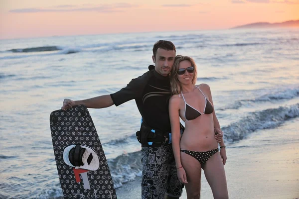 Пара серфингистов позирует на пляже на закате — стоковое фото