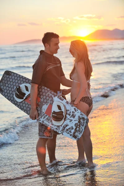 Surf pari poseeraa rannalla auringonlaskun — kuvapankkivalokuva