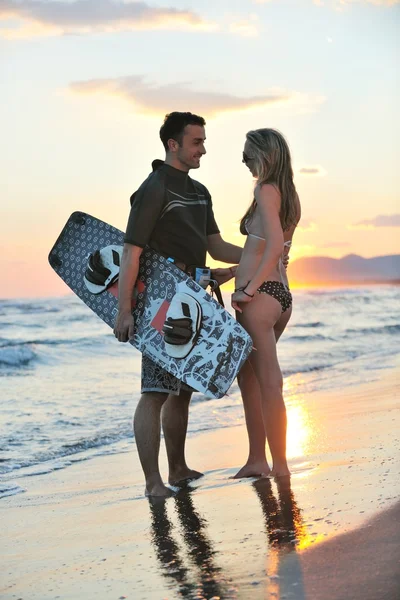 Couple de surf posant à la plage au coucher du soleil — Photo