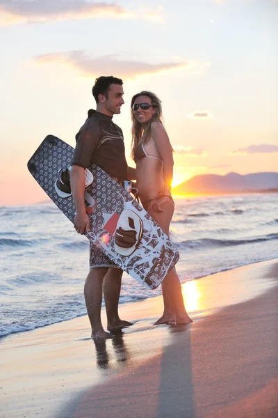 Couple de surf posant à la plage au coucher du soleil — Photo