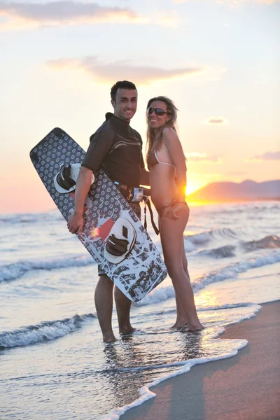 Para surf pozowanie na plaży na zachód słońca — Zdjęcie stockowe