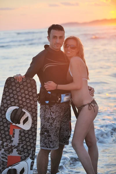 Surf casal posando na praia ao pôr do sol — Fotografia de Stock