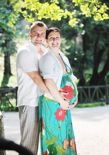 Szczęśliwa para ciąży w piękny słoneczny dzień w parku — Zdjęcie stockowe