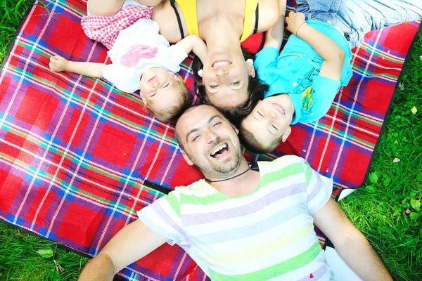 Feliz jovem casal com seus filhos se divertir no parque — Fotografia de Stock