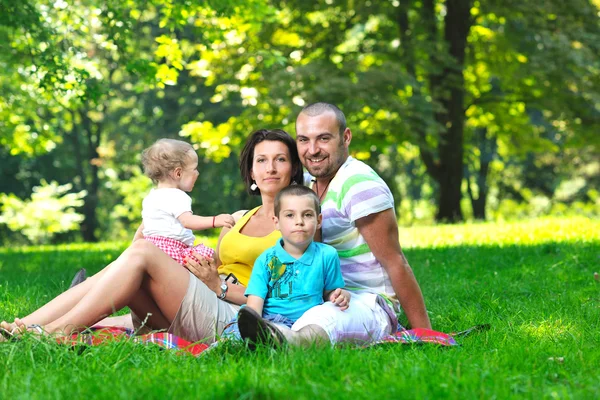 Mutlu genç çift çocuklarıyla birlikte park eğlenmek — Stok fotoğraf
