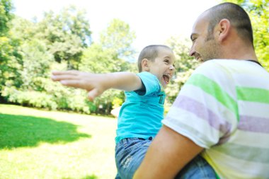 Happy father and son have fun at park clipart