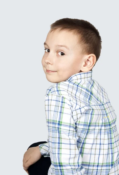 Portret van een jongen op een grijze achtergrond. — Stockfoto
