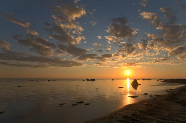 Pôr do sol acima das pedras do mar — Fotografia de Stock