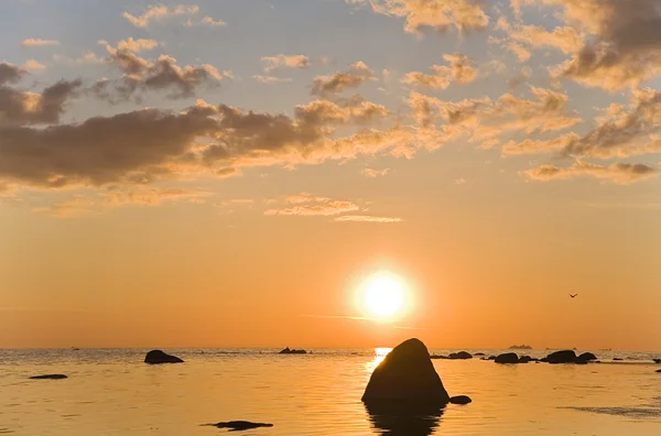 Помаранчеве сонце над морськими каменями — стокове фото